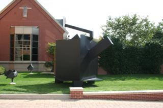 Large metal sculpture that looks like a teapot.